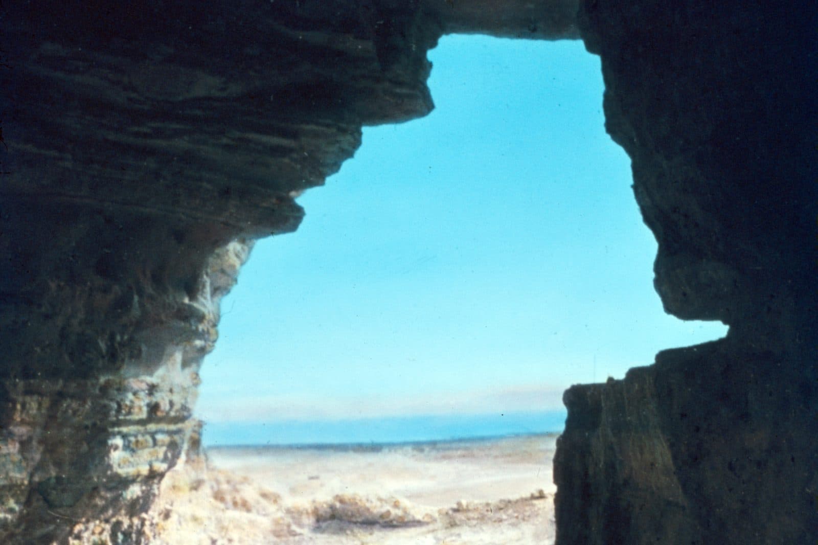 Looking out from a rocky cave at Qumran toward the Dead Sea in the distance