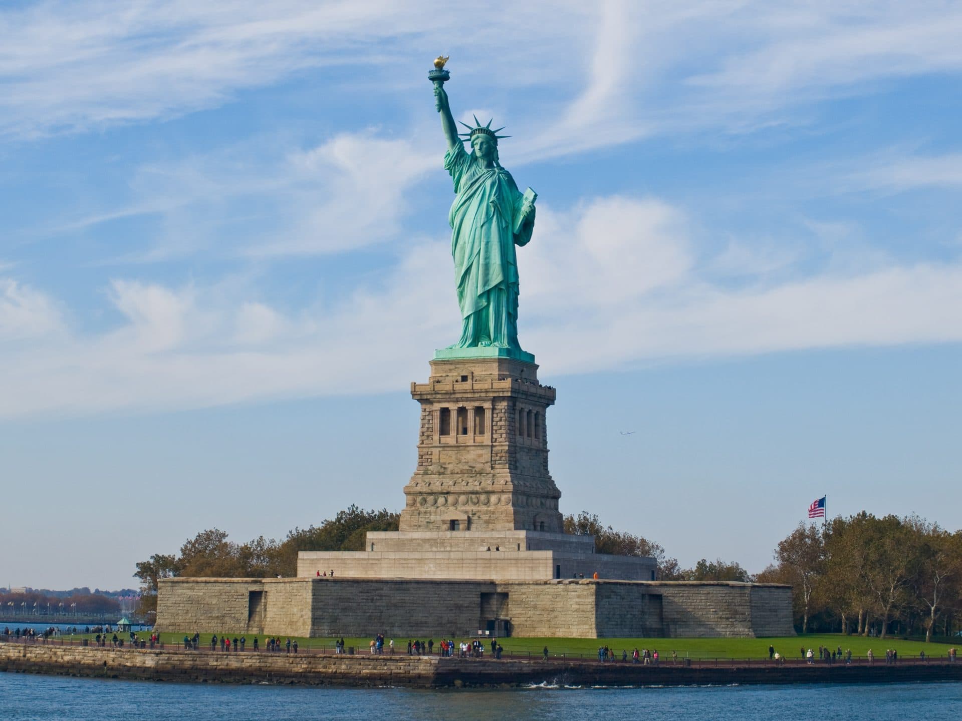 The Statue of Liberty on its pedestal on Liberty Island, New York, under a blue sky