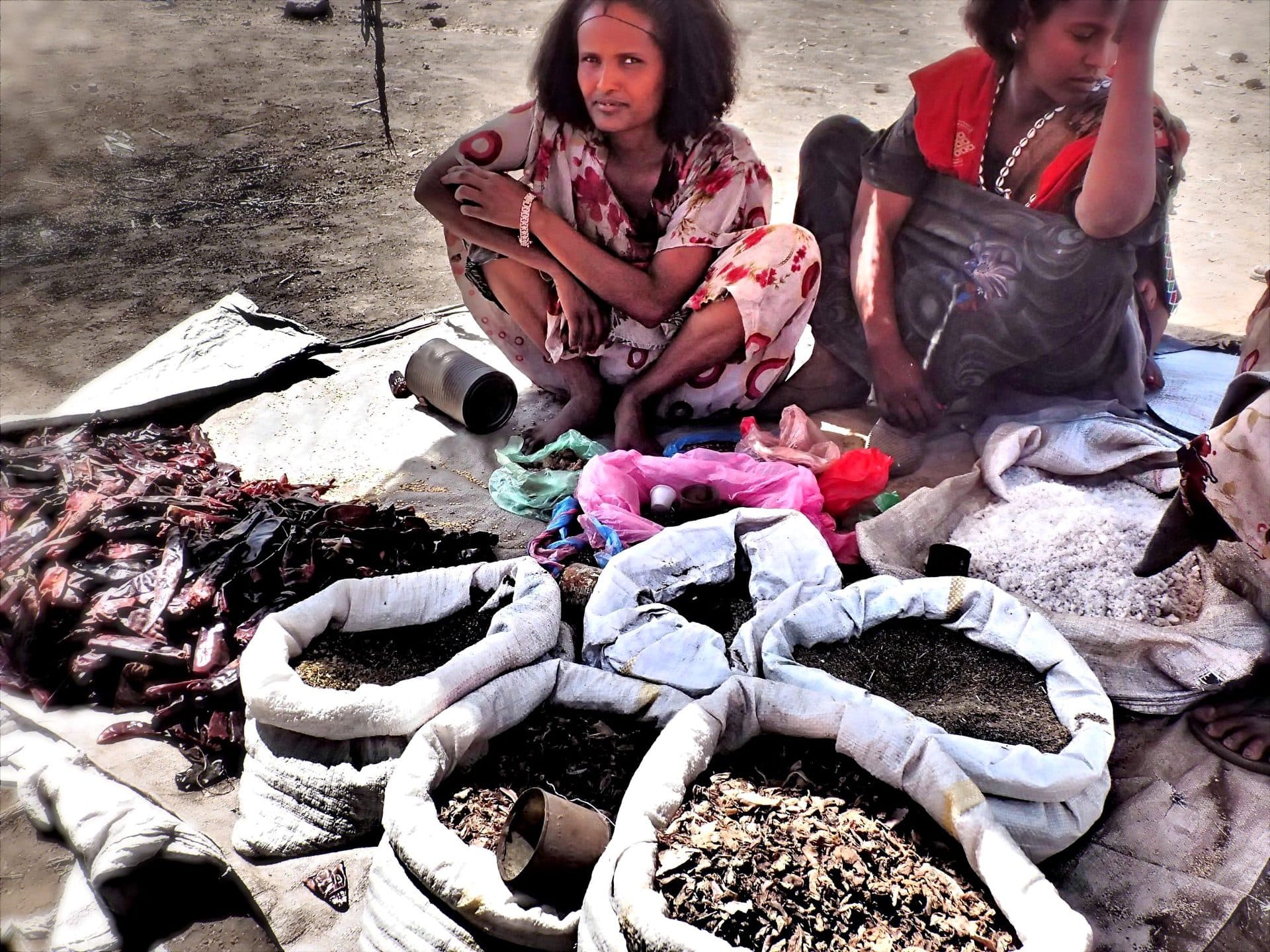 Women selling grain and goods from open sacks on market day in Oromia, Ethiopia