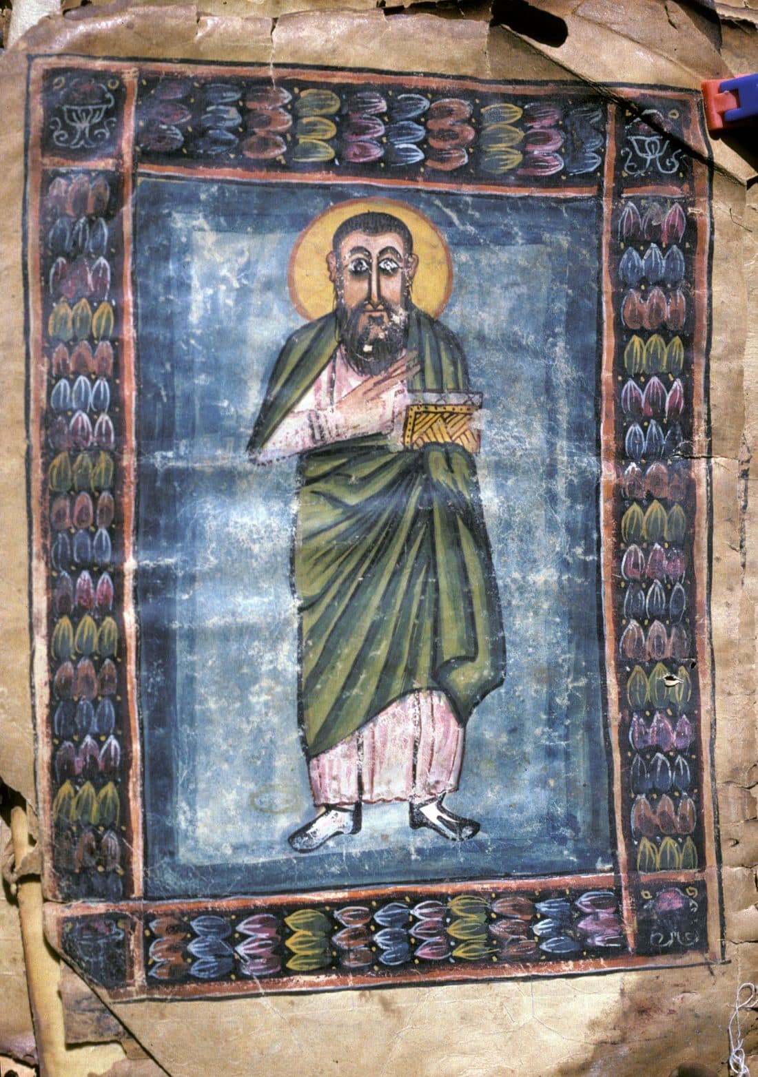 A painted portrait of a robed figure holding a book inside a decorated border, from an Ethiopian Gospel book