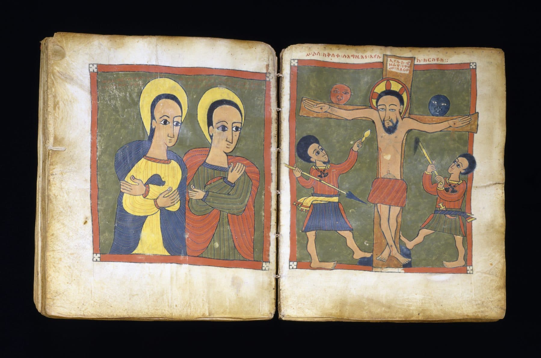 An open Ethiopian Gospel book with brightly painted figures on facing pages
