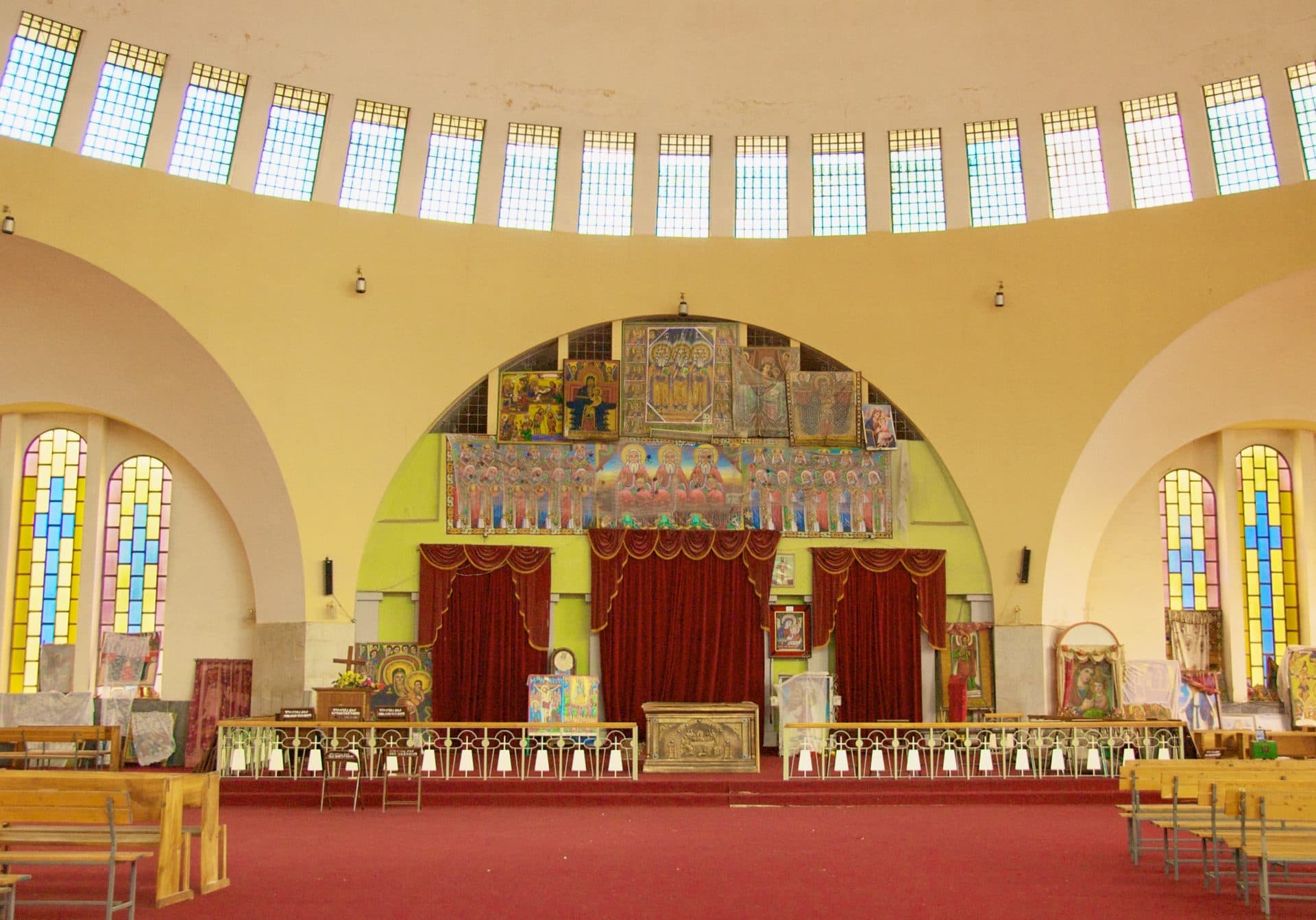 The interior of the New Church of St. Mary of Zion in Axum, with arches, painted panels and draped sanctuary entrances