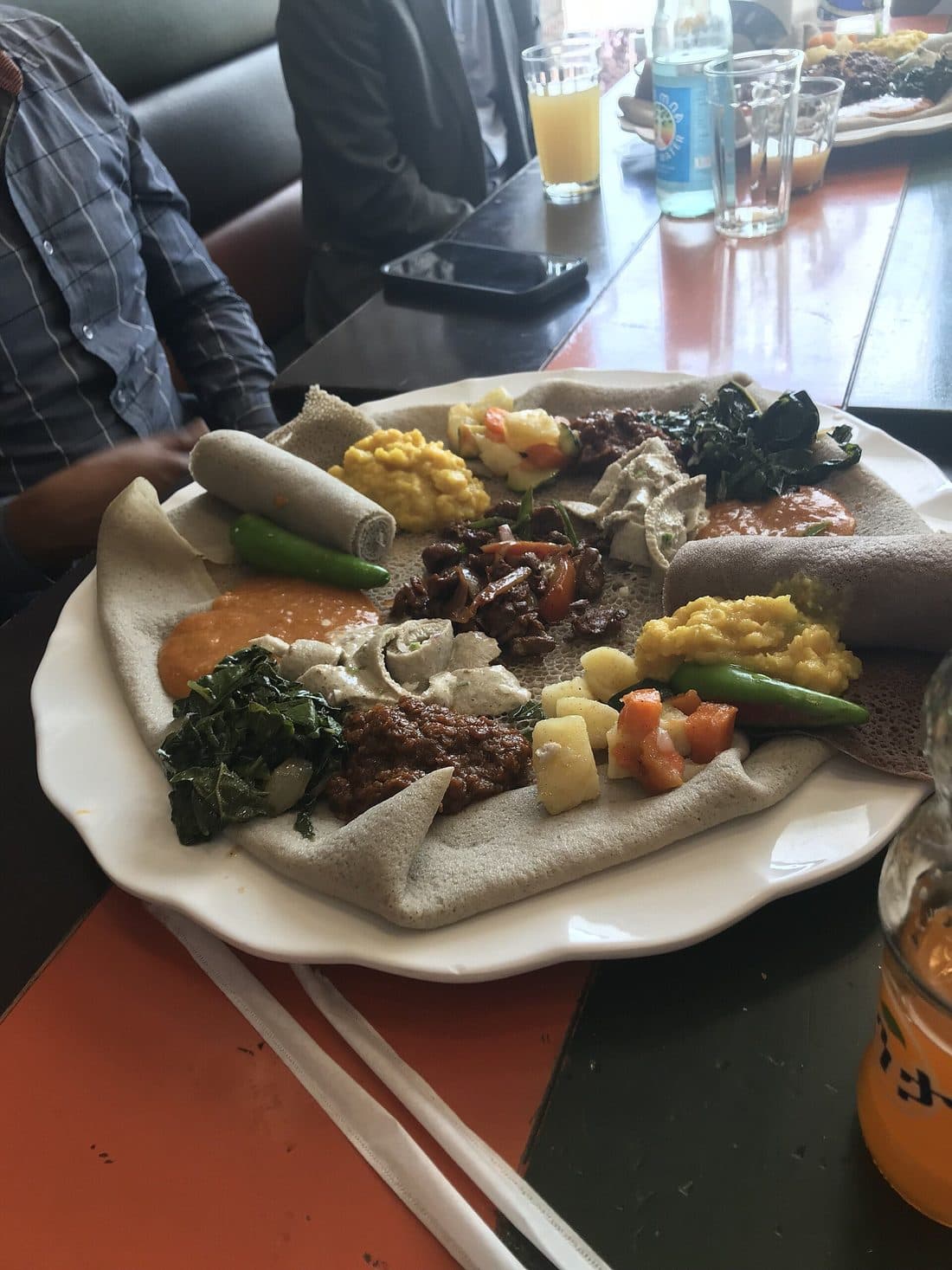A fasting platter of colorful vegetable dishes and greens served on injera