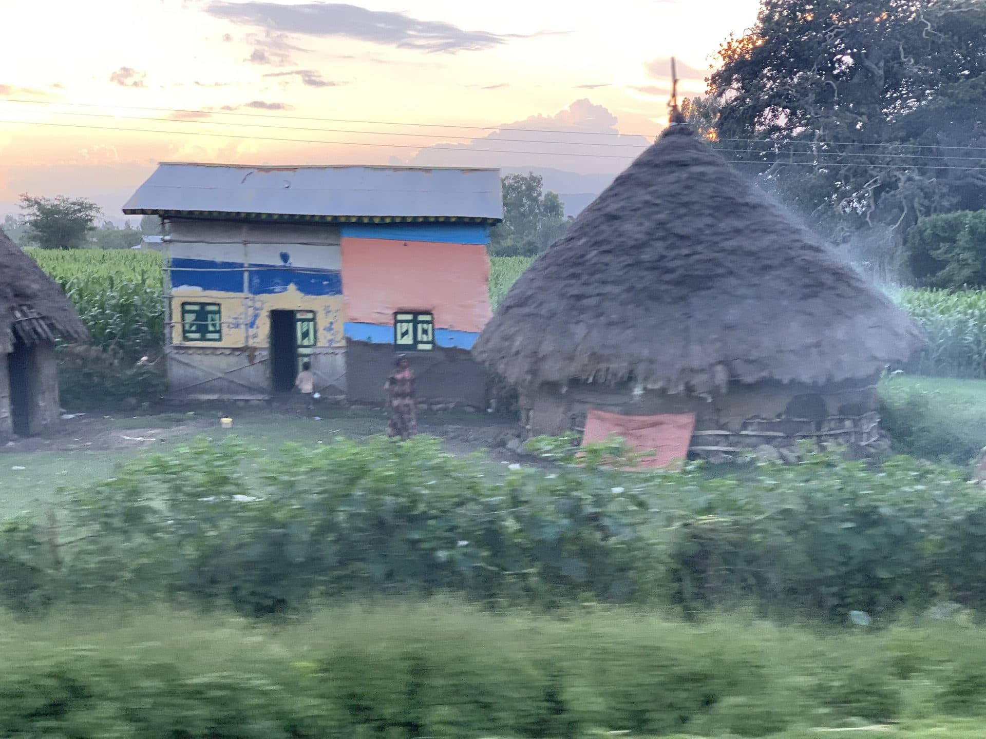 A round thatched tukul house beside a painted cinder-block home near Butajira, in Ethiopia's Gurage Zone
